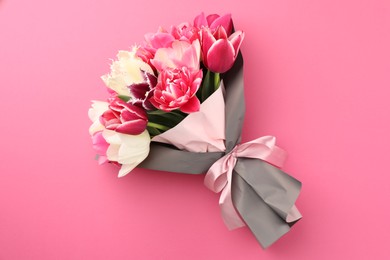 Photo of Bouquet of beautiful tulips on pink background, top view