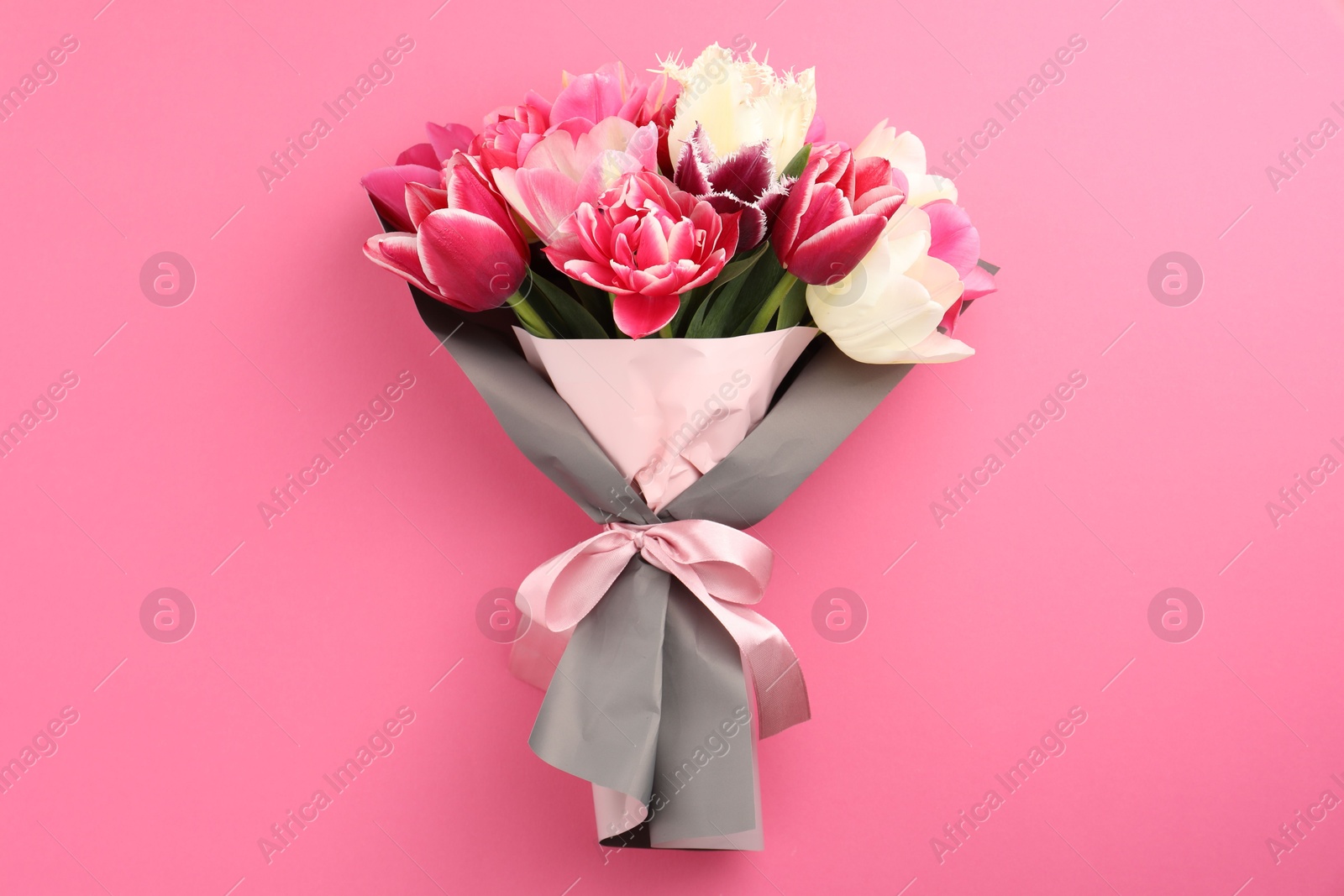 Bouquet of beautiful tulips on pink background, top view Photo of Bouquet of beautiful tulips on pink background, top view