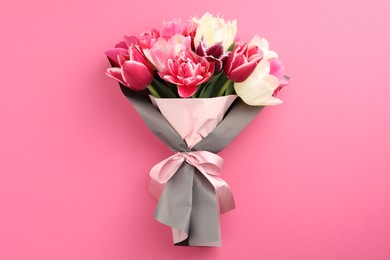 Photo of Bouquet of beautiful tulips on pink background, top view