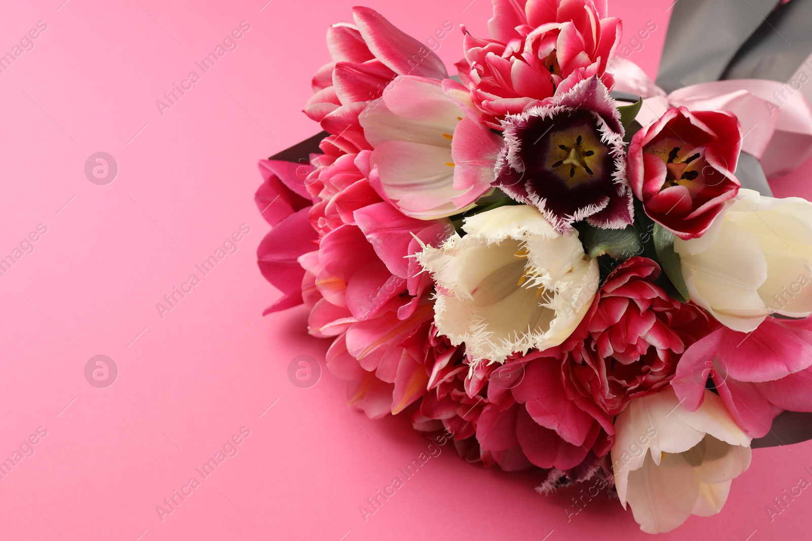 Photo of Bouquet of beautiful tulips on pink background, closeup