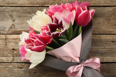 Photo of Bouquet of beautiful tulips on wooden background, top view