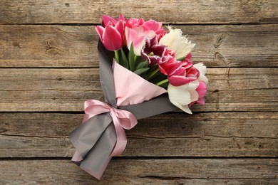 Photo of Bouquet of beautiful tulips on wooden background, top view