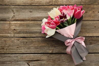Photo of Bouquet of beautiful tulips on wooden background, top view. Space for text