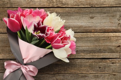 Photo of Bouquet of beautiful tulips on wooden background, top view. Space for text