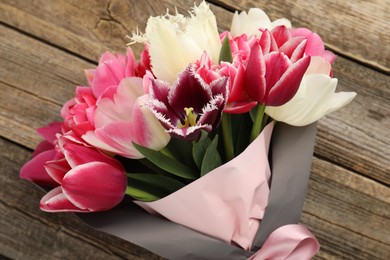 Photo of Bouquet of beautiful tulips on wooden background, closeup