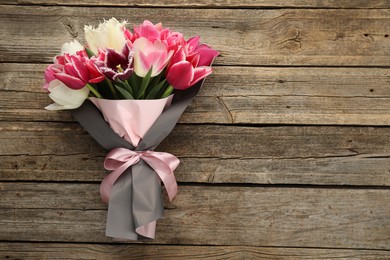 Photo of Bouquet of beautiful tulips on wooden background, top view. Space for text