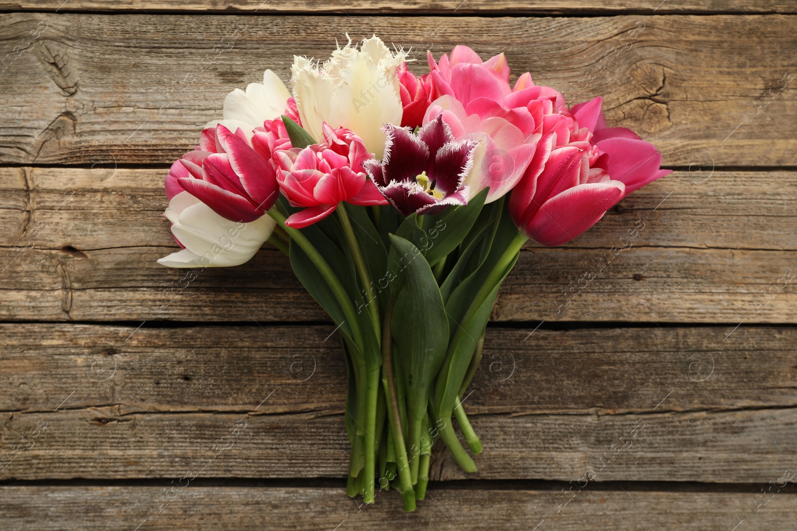 Photo of Beautiful tulips on wooden background, top view