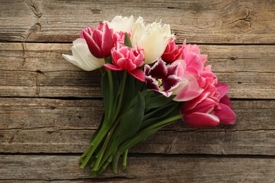 Photo of Beautiful tulips on wooden background, top view