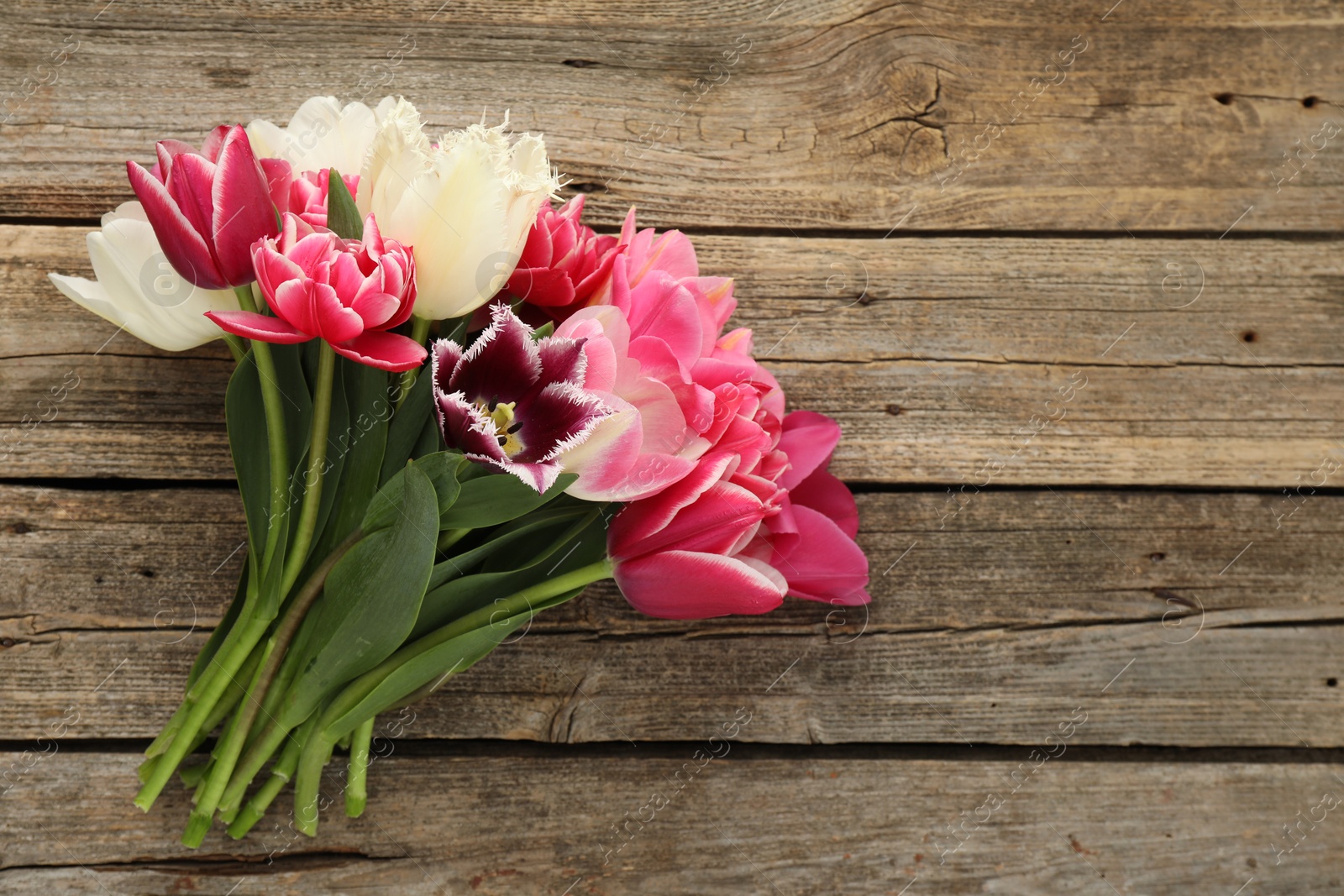 Beautiful tulips on wooden background, top view. Space for text Photo of Beautiful tulips on wooden background, top view. Space for text
