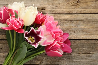 Photo of Beautiful tulips on wooden background, top view. Space for text