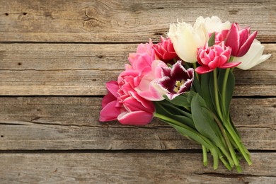 Photo of Beautiful tulips on wooden background, top view. Space for text