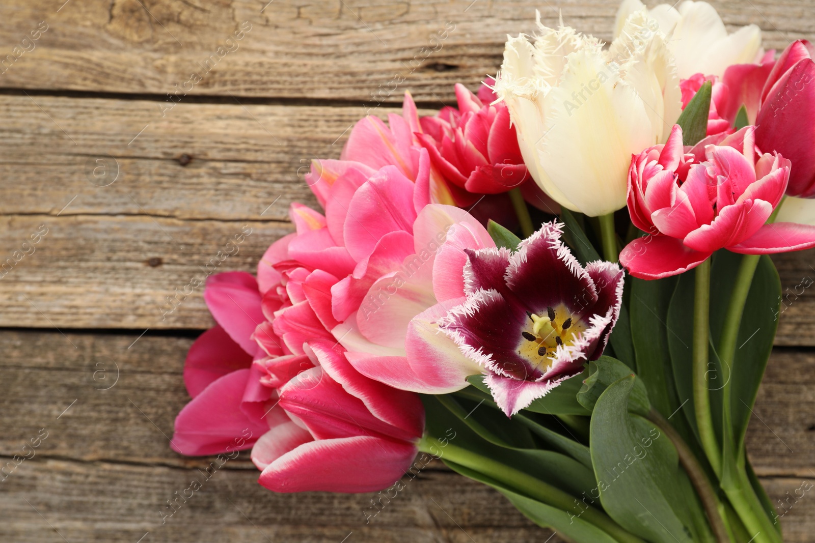 Beautiful tulips on wooden background, top view Photo of Beautiful tulips on wooden background, top view