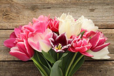 Photo of Beautiful tulips on wooden background, top view