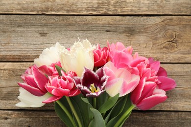 Photo of Beautiful tulips on wooden background, top view