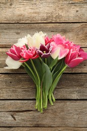Photo of Beautiful tulips on wooden background, top view