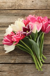 Photo of Beautiful tulips on wooden background, top view