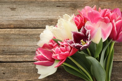 Photo of Beautiful tulips on wooden background, top view. Space for text
