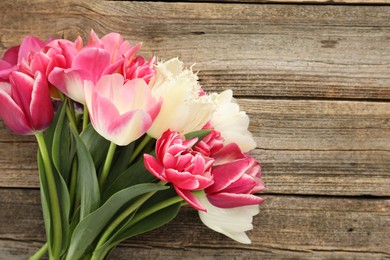 Photo of Beautiful tulips on wooden background, top view. Space for text