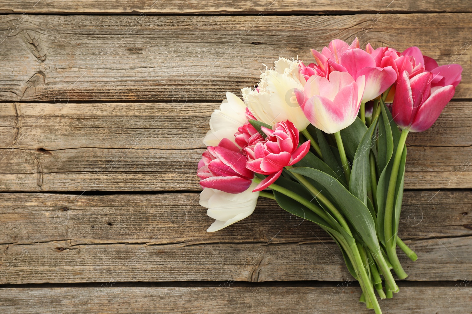 Beautiful tulips on wooden background, top view Photo of Beautiful tulips on wooden background, top view