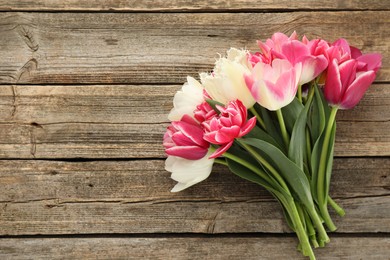 Photo of Beautiful tulips on wooden background, top view