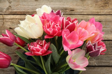 Photo of Beautiful tulip flowers on wooden background, closeup