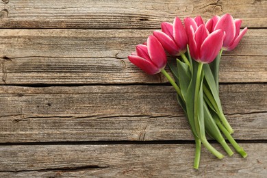 Photo of Beautiful tulips on wooden background, top view. Space for text