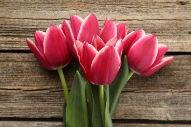 Photo of Beautiful tulips on wooden background, top view