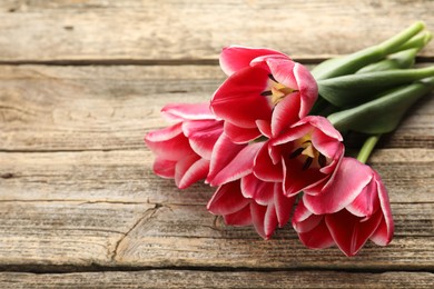 Photo of Beautiful tulip flowers on wooden background, closeup