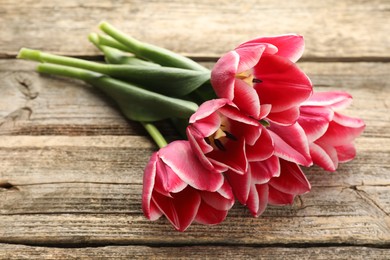 Photo of Beautiful tulip flowers on wooden background, closeup