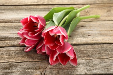 Photo of Beautiful tulip flowers on wooden background, closeup