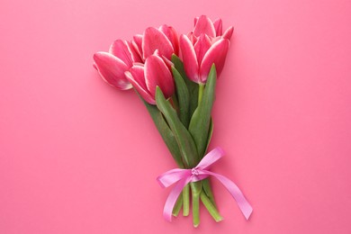 Photo of Bouquet of beautiful tulips on pink background, top view