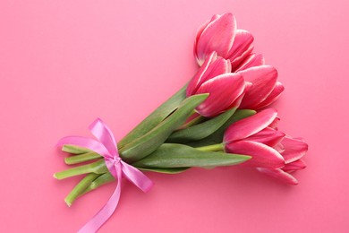 Photo of Bouquet of beautiful tulips on pink background, top view
