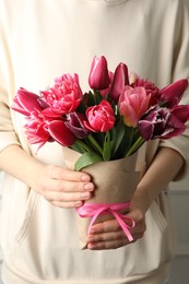 Photo of Woman with bouquet of beautiful tulips on white background, closeup