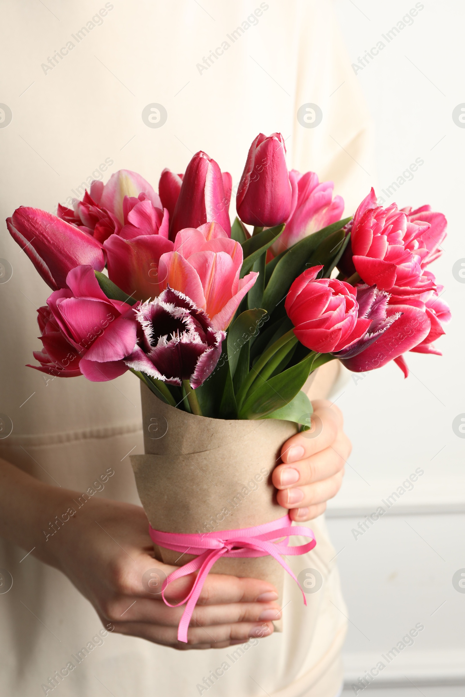 Photo of Woman with bouquet of beautiful tulips on white background, closeup