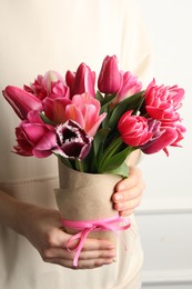 Photo of Woman with bouquet of beautiful tulips on white background, closeup