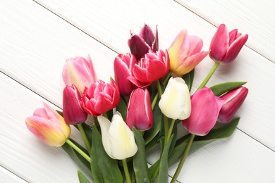 Photo of Beautiful tulips on white wooden background, top view