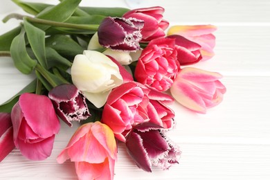 Photo of Beautiful tulips on white wooden background, closeup