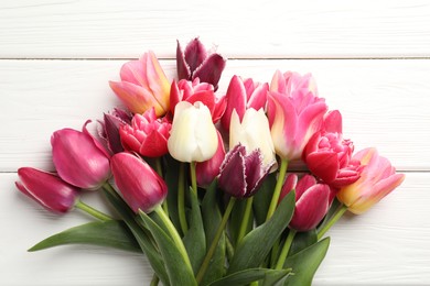 Photo of Beautiful tulips on white wooden background, top view