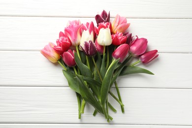 Photo of Beautiful tulips on white wooden background, top view