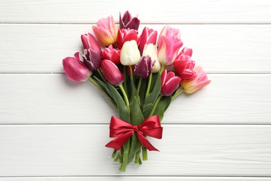 Photo of Bouquet of beautiful tulips on white wooden background, top view