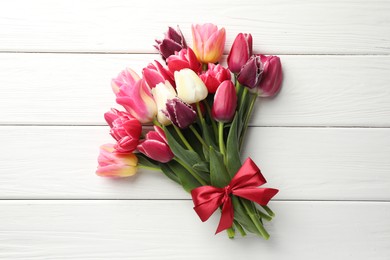 Photo of Bouquet of beautiful tulips on white wooden background, top view