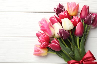 Photo of Bouquet of beautiful tulips on white wooden background, top view. Space for text