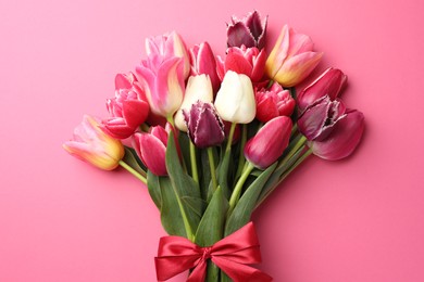 Photo of Bouquet of beautiful tulips on pink background, top view