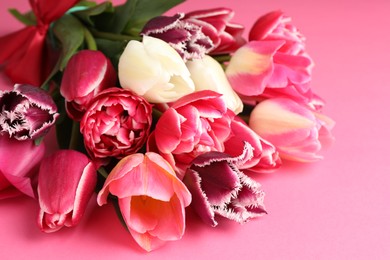 Photo of Beautiful tulip flowers on pink background, closeup