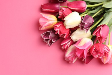 Photo of Beautiful tulip flowers on pink background, top view. Space for text