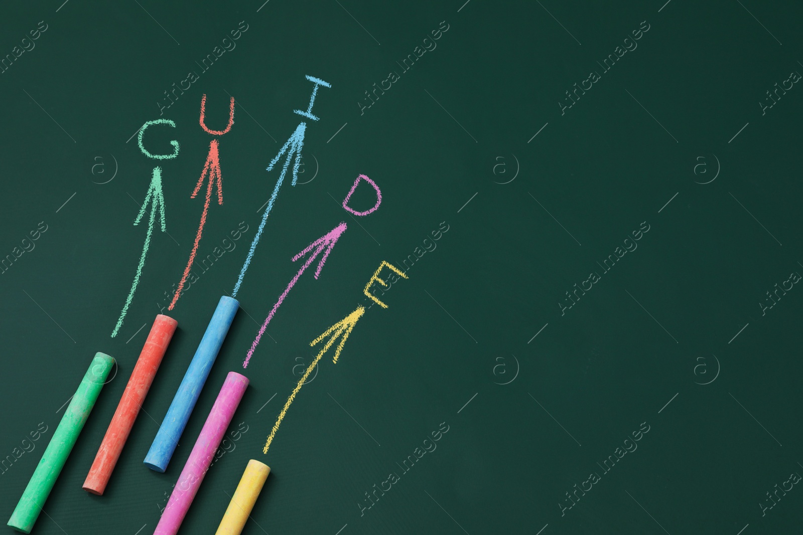 Word Guide, drawn arrows and pieces of colorful chalk on green chalkboard, top view Image of Word Guide, drawn arrows and pieces of colorful chalk on green chalkboard, top view