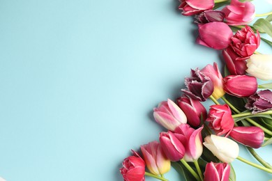 Photo of Beautiful tulips on light blue background, flat lay. Space for text