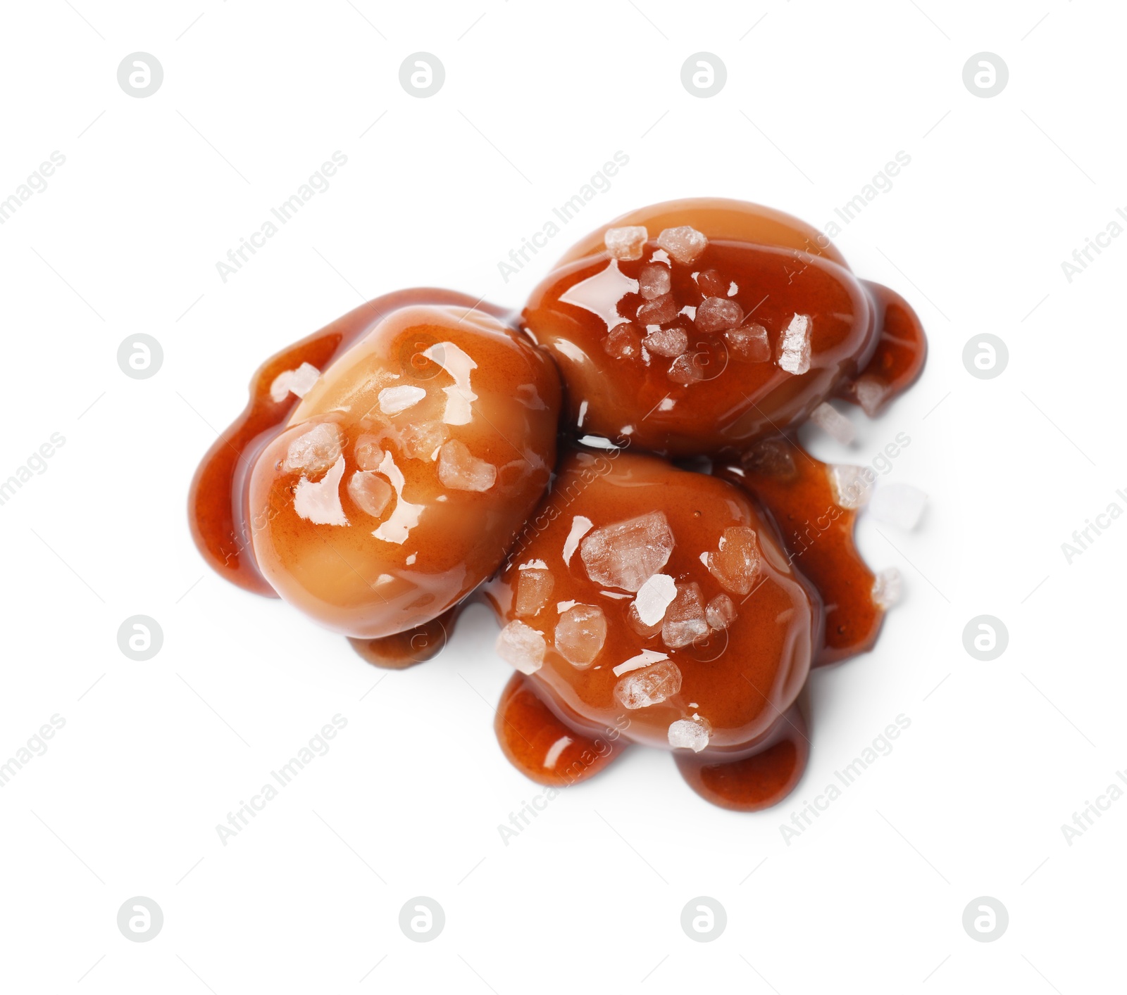 Photo of Tasty sweet candies, salt and caramel sauce isolated on white, top view