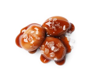 Photo of Tasty sweet candies, salt and caramel sauce isolated on white, top view