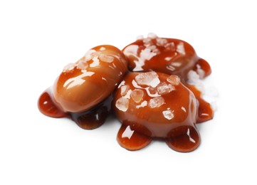 Photo of Tasty sweet candies, salt and caramel sauce isolated on white